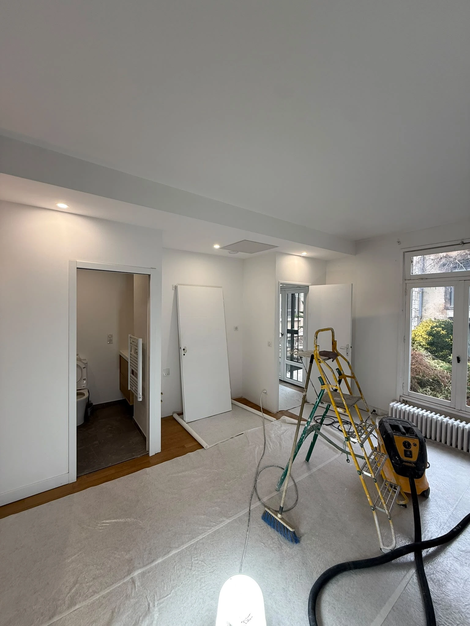 Chambre sous toiture en cours de rénovation, protections de sol et outillage